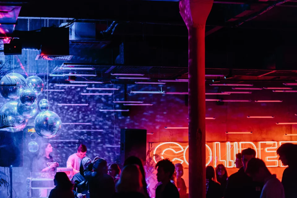 People Standing On Stage With Red Lights